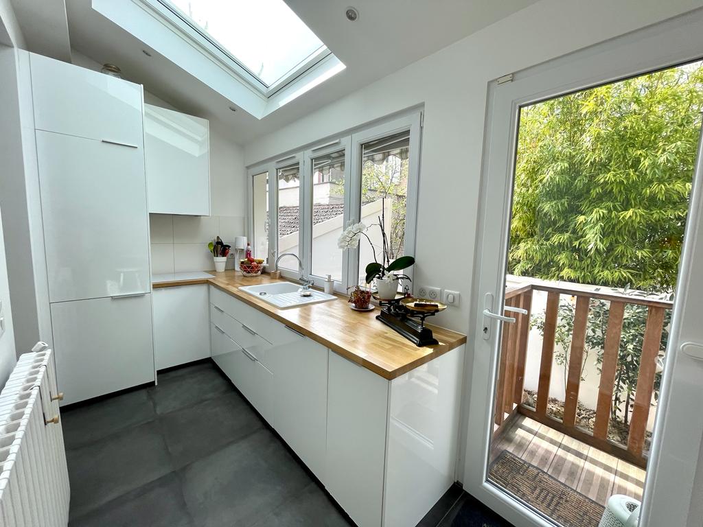 Une cuisine rénovée et lumineuse avec des meubles sur-mesure. 